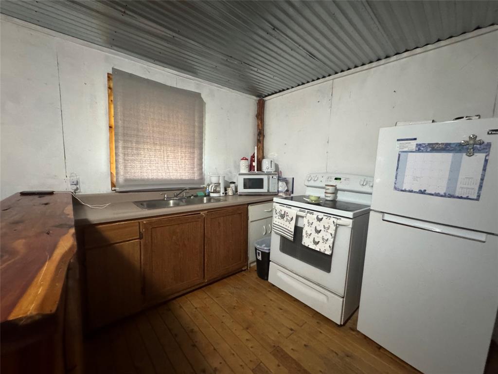 608 Cherokee Street Bellmead, TX 76705 - Photo 26 of 38 a kitchen with granite countertop white cabinets and white appliances