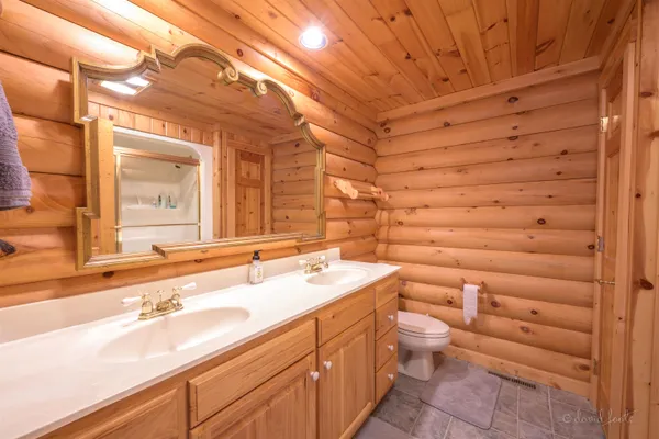 a bathroom with a double vanity sink mirror and shower
