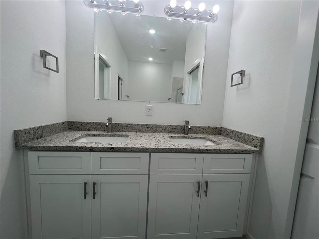 187 Sesame Road East Rotonda West, FL 33947 - Photo 18 of 28 a bathroom with a granite countertop sink a light fixture and a mirror