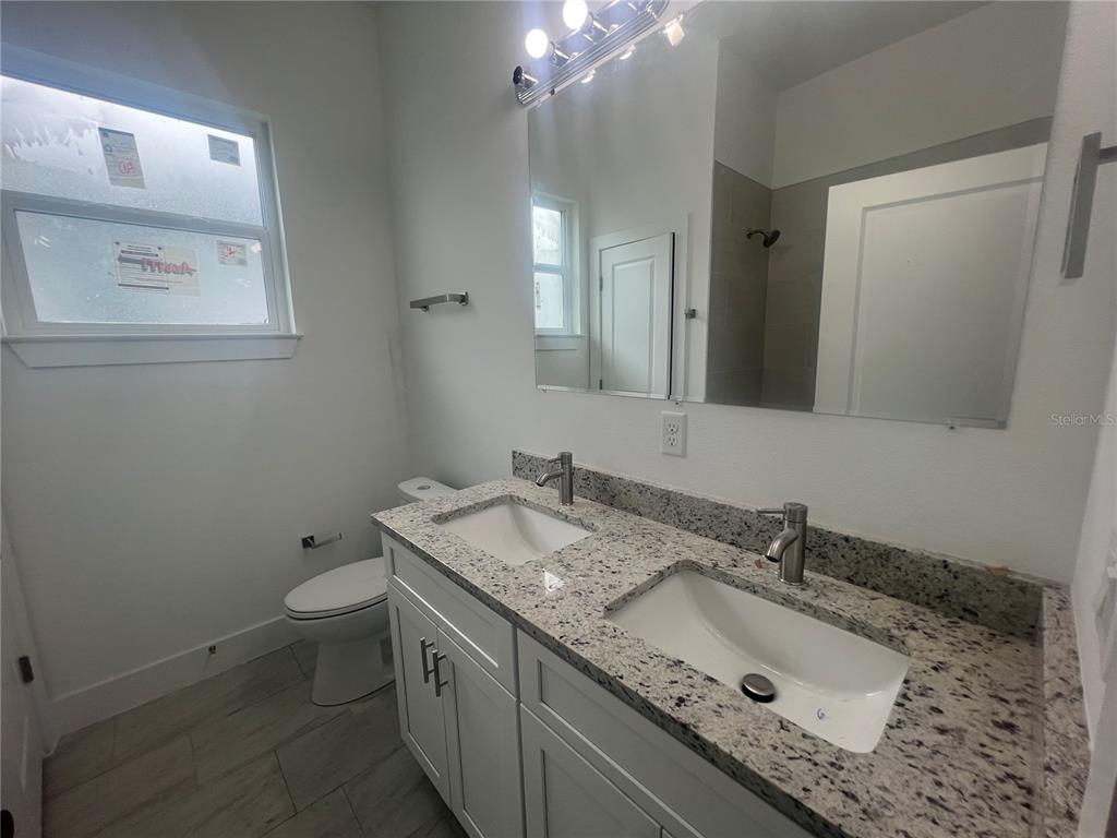 187 Sesame Road East Rotonda West, FL 33947 - Photo 22 of 28 a bathroom with a granite countertop sink toilet and mirror