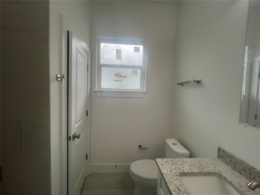 187 Sesame Road East Rotonda West, FL 33947 - Photo 23 of 28 a bathroom with a granite countertop toilet and a sink