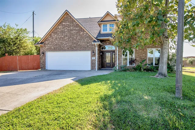 a front view of a house with a yard and trees