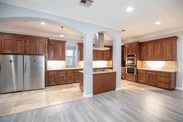 a kitchen with refrigerator and wooden floor