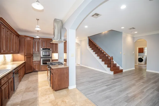 a kitchen with stainless steel appliances kitchen island a stove and a refrigerator