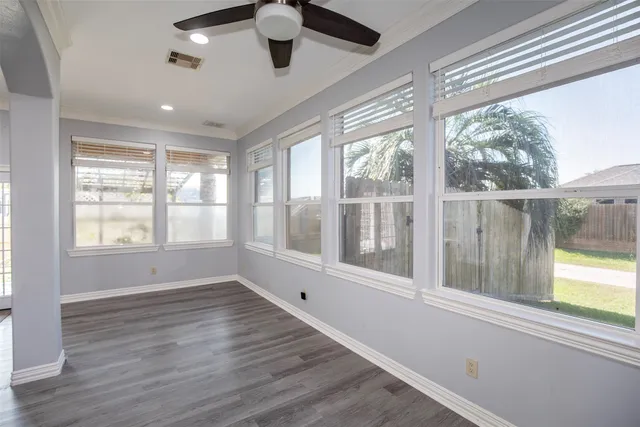 a view of a hallway with wooden floor and a kitchen space with a sink