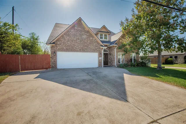 a front view of a house with a garden and trees