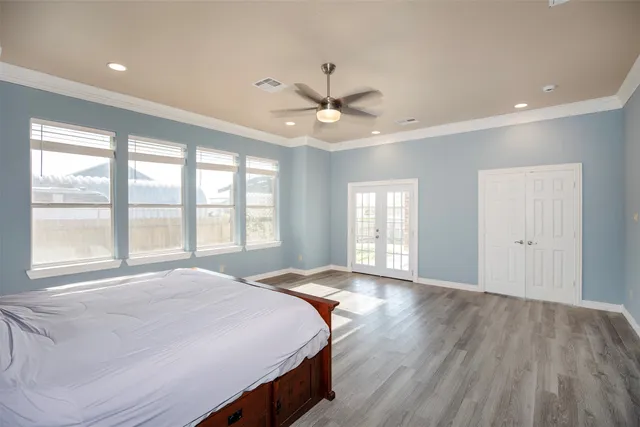 a spacious bedroom with a large bed large window with wooden floor