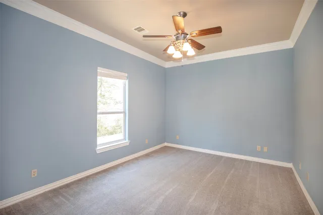 an empty room with a window and a fan