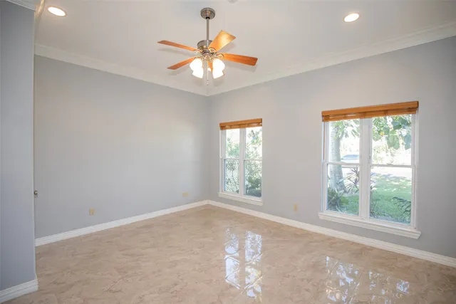 an empty room with a chandelier fan and closet area