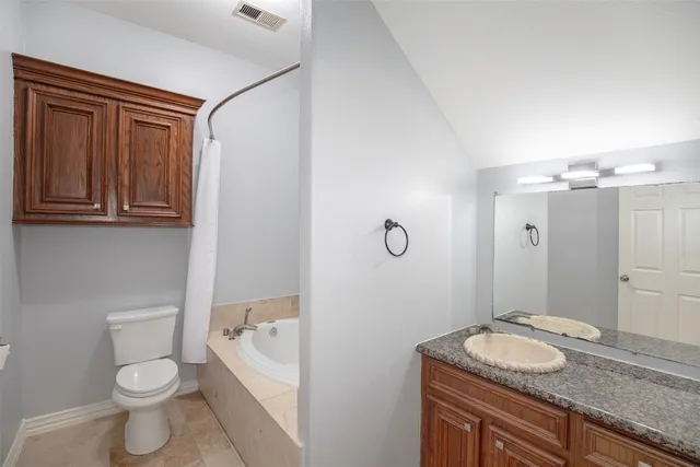 a kitchen with stainless steel appliances kitchen island granite countertop a refrigerator and wooden cabinets