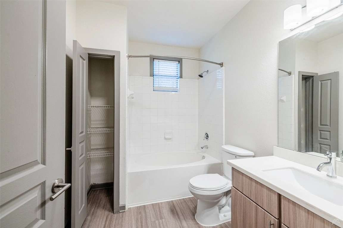 8515 Interstate 35, Unit 11102 Austin, TX 78744 - Photo 16 of 25 Bathroom featuring vanity, shower combination, and light wood-type flooring