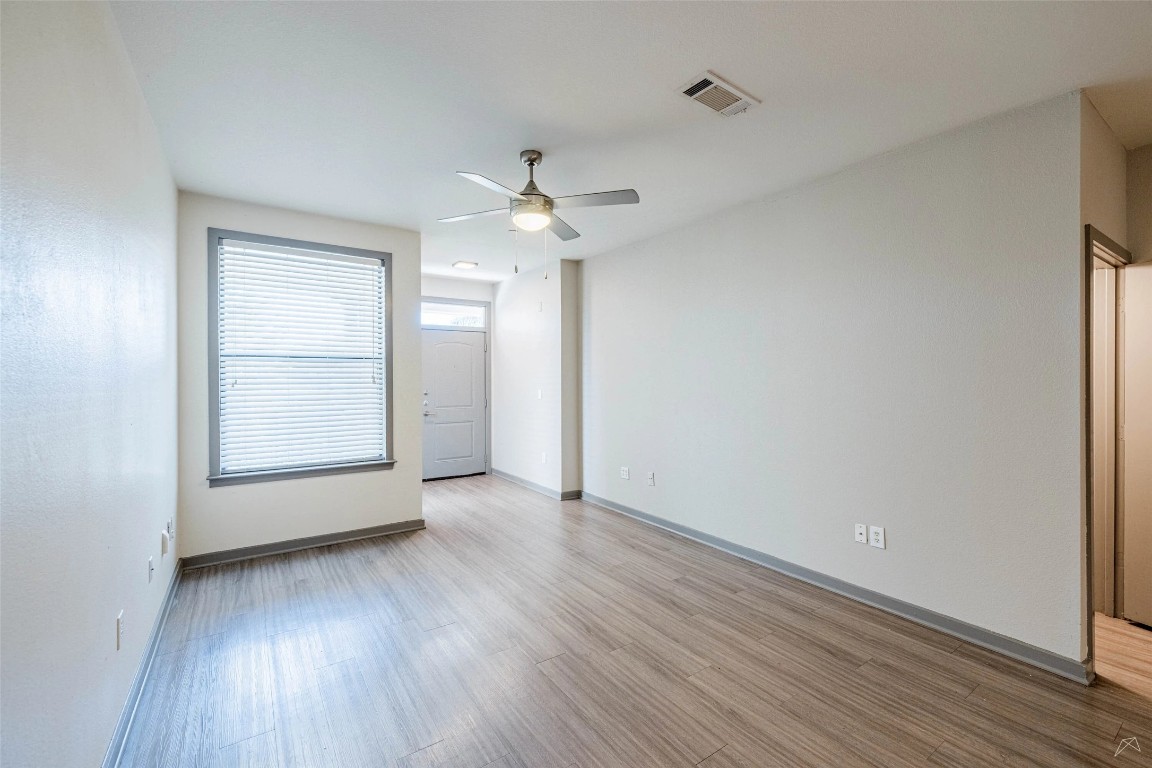 8515 Interstate 35, Unit 11102 Austin, TX 78744 - Photo 10 of 25 Unfurnished room featuring light wood finished floors and a ceiling fan