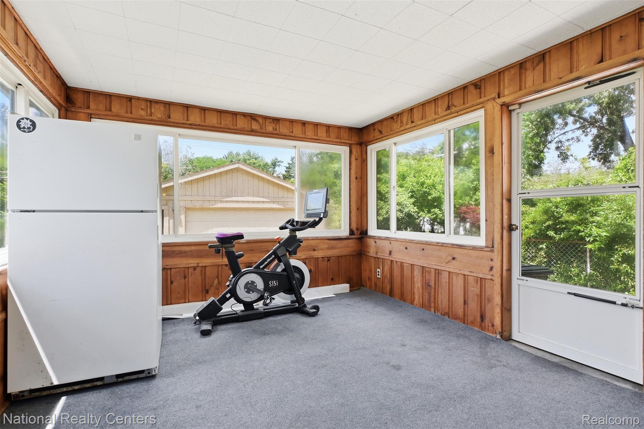 17159 Rougeway Street Livonia, MI 48152 - Photo 19 of 36 Sunroom featuring wood paneling, multiple windows, and a white screen door