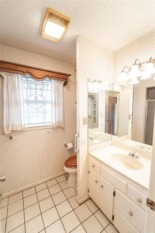 a spacious bathroom with a granite countertop sink mirror and bathtub