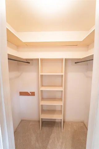 an empty room with windows and chandelier fan