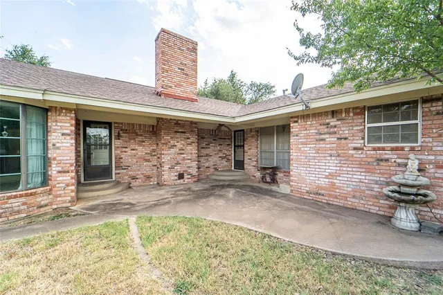 a view of a house with a yard and hanging chair