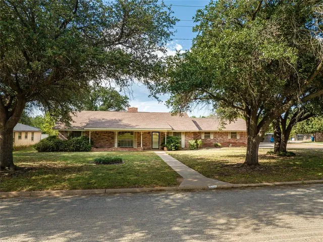 a view of a house with a yard and potted plants