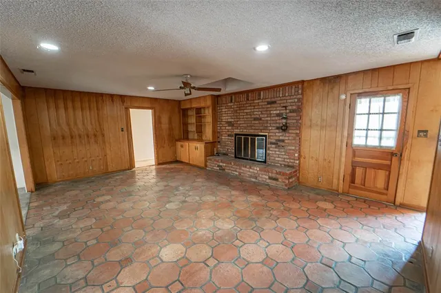 an empty room with fireplace and windows