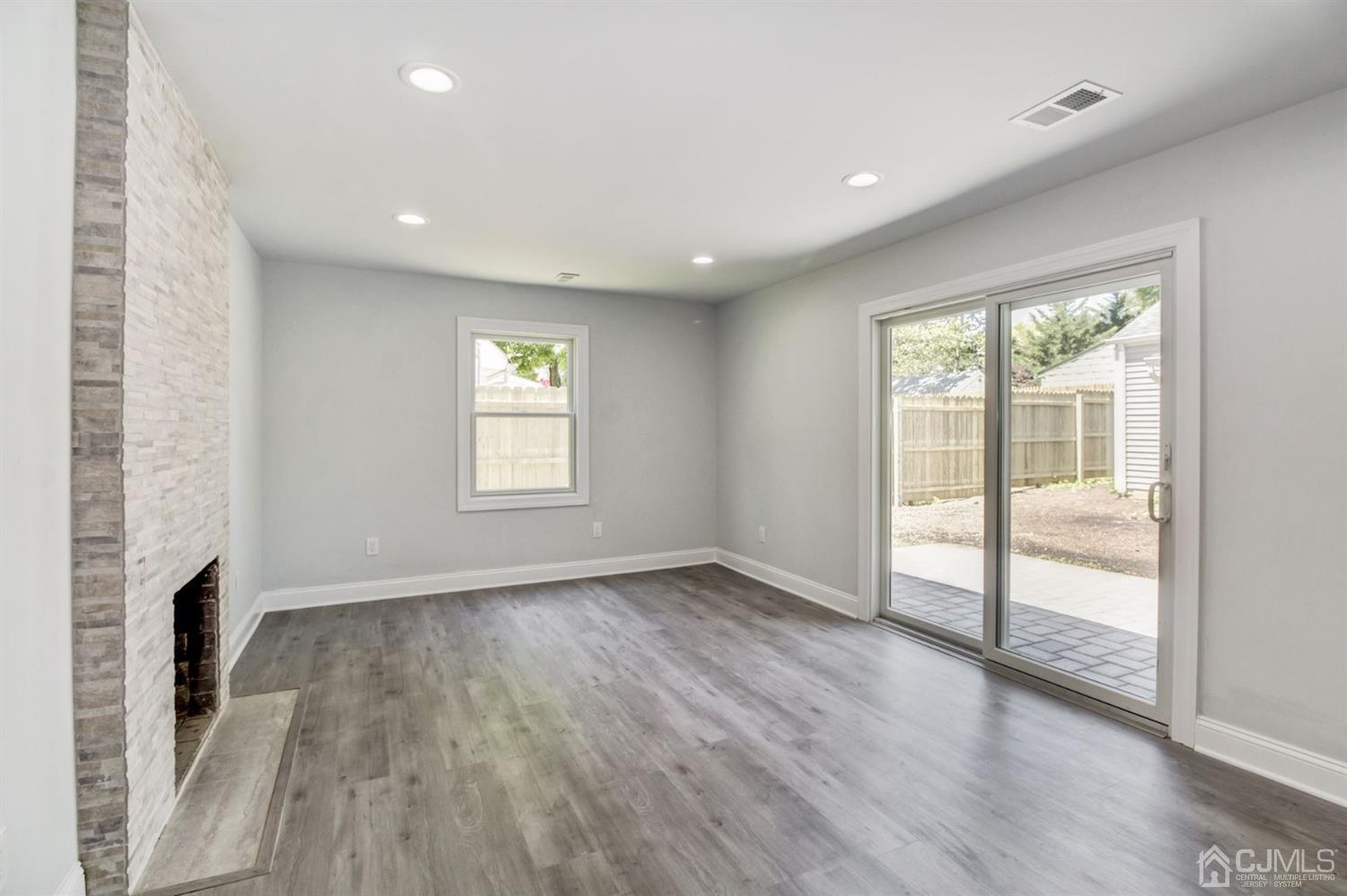 126 Greenbrook Road Green Brook, NJ 08812 - Photo 15 of 36 an empty room with wooden floor and a fireplace