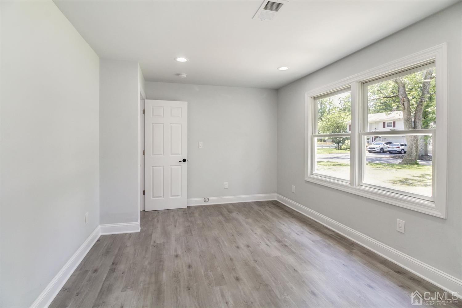 126 Greenbrook Road Green Brook, NJ 08812 - Photo 18 of 36 an empty room with wooden floor and windows