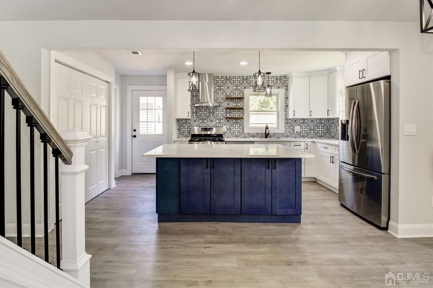 126 Greenbrook Road Green Brook, NJ 08812 - Photo 5 of 36 a kitchen with kitchen island granite countertop wooden cabinets a refrigerator and a sink
