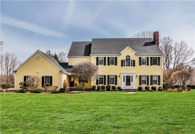 44 Barry Avenue Ridgefield, CT 06877 - Photo 1 of 1 a front view of a house with a garden and trees