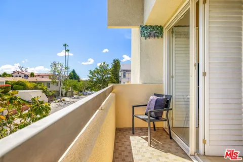 a balcony with wooden floor and outdoor seating
