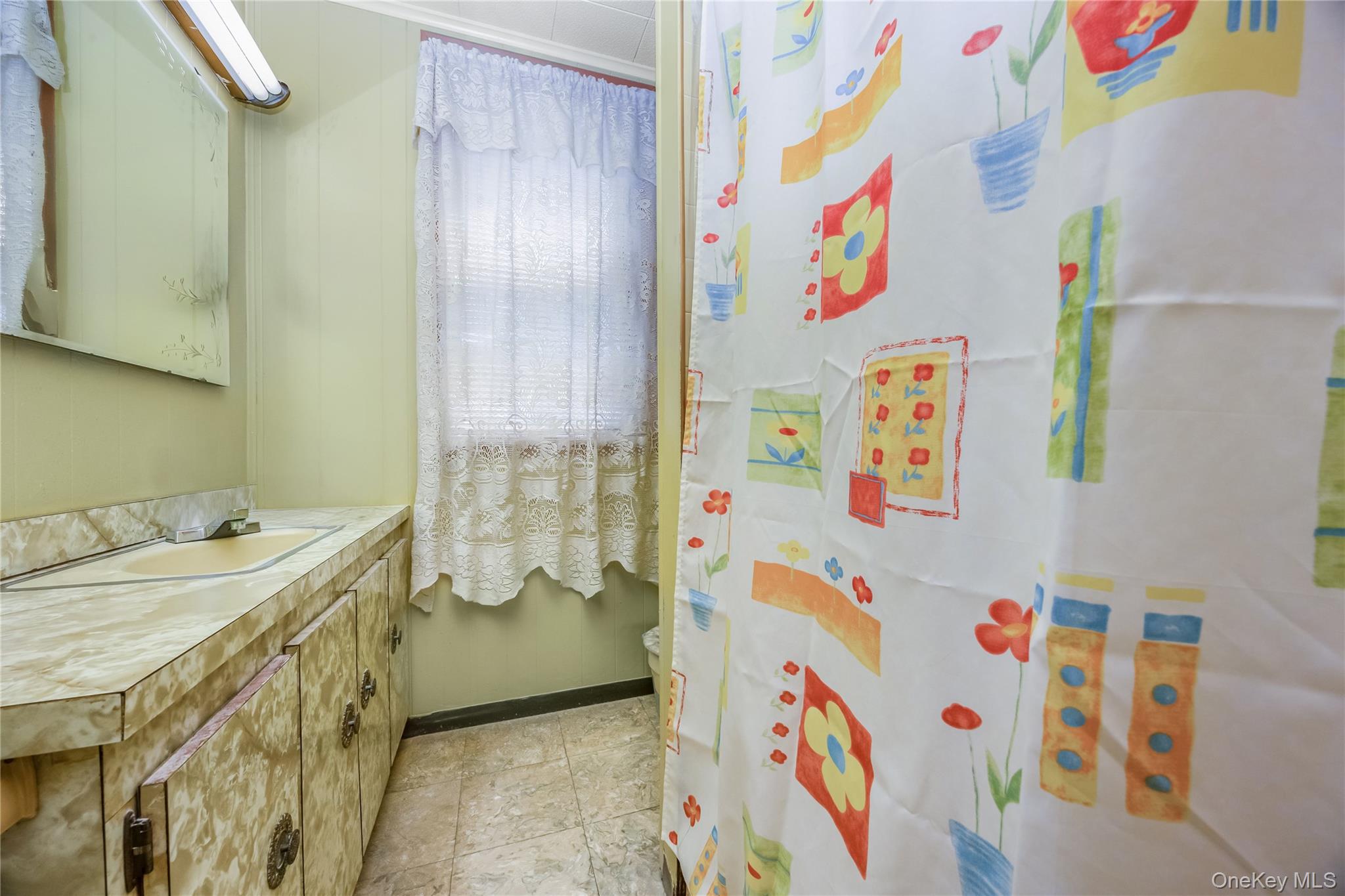 80-50 88th Road Queens, NY 11421 - Photo 17 of 21 a bathroom with a sink a vanity and a shower curtain