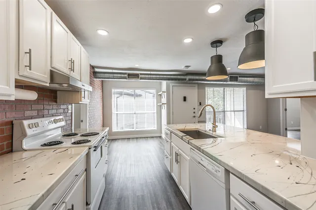 a kitchen with a sink a stove and chairs