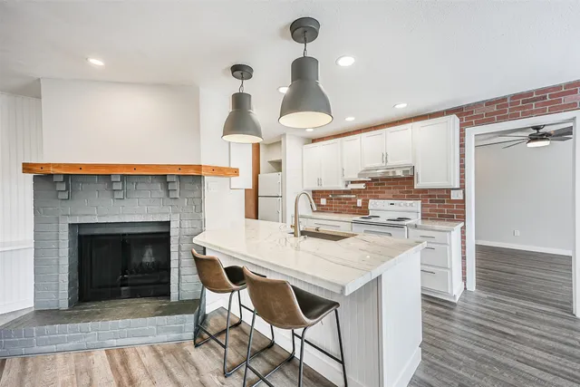 a kitchen with stainless steel appliances a sink a refrigerator and cabinets