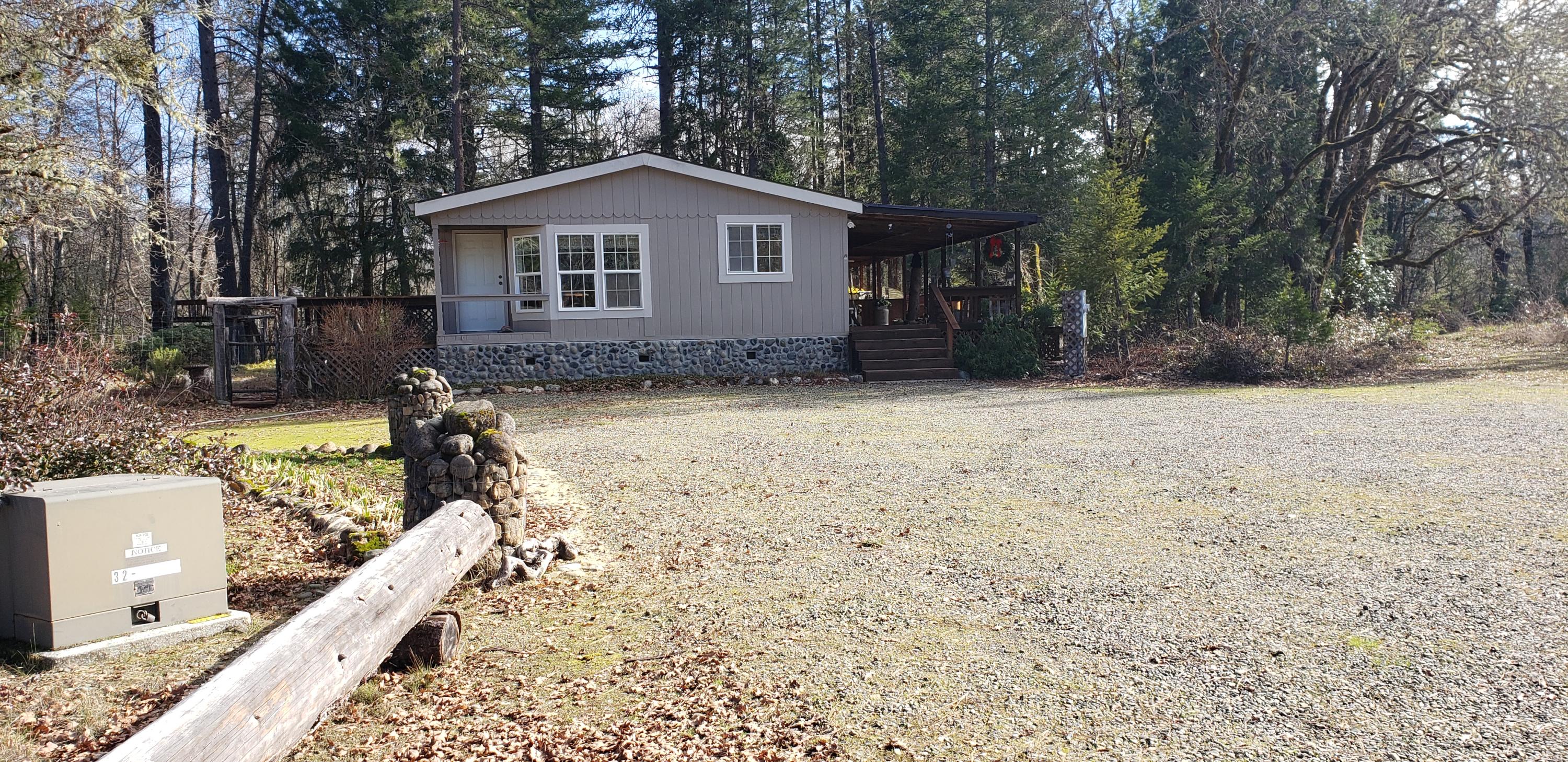 5865 Rockydale Road Cave Junction, OR 97523 - Photo 1 of 38 front end of home, covered deck on right side. Hot tub on this side of home.