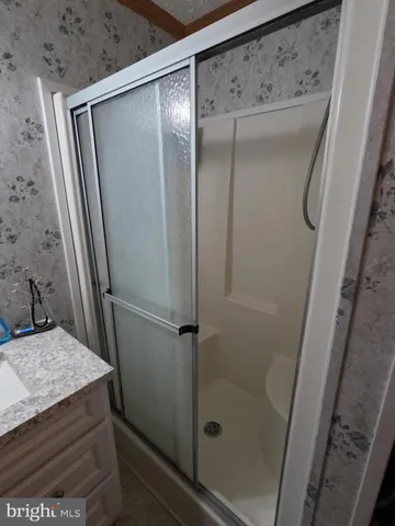 a bathroom with a granite countertop shower and a sink