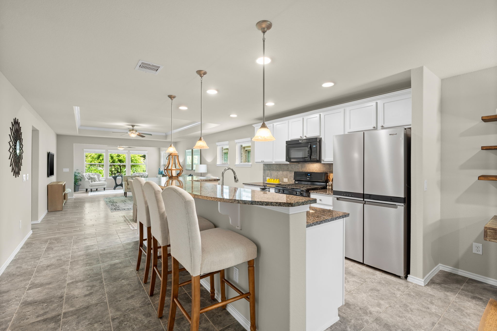 a kitchen with refrigerator a sink and chairs