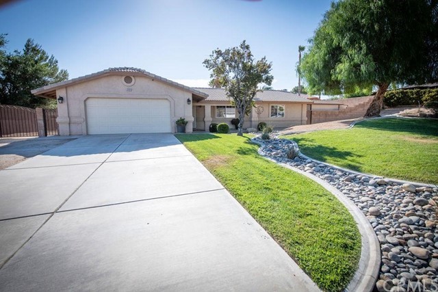16184 Tude Road Apple Valley, CA 92307 - Photo 1 of 1 a front view of a house with a yard and potted plants
