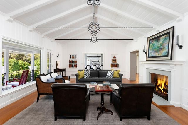 a living room with fireplace furniture and a large window