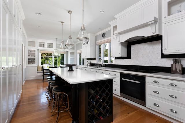 a kitchen with stainless steel appliances granite countertop a sink a stove and a wooden floors