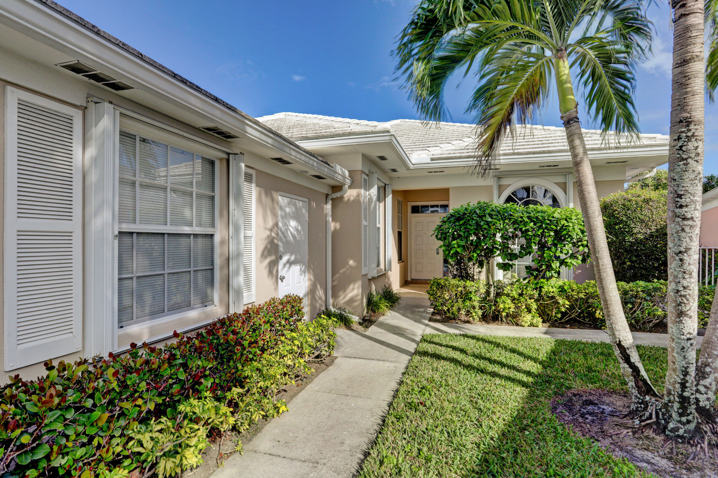 8452 Beaconhill Road Palm Beach Gardens, FL 33410 - Photo 1 of 40 a front view of a house with a yard