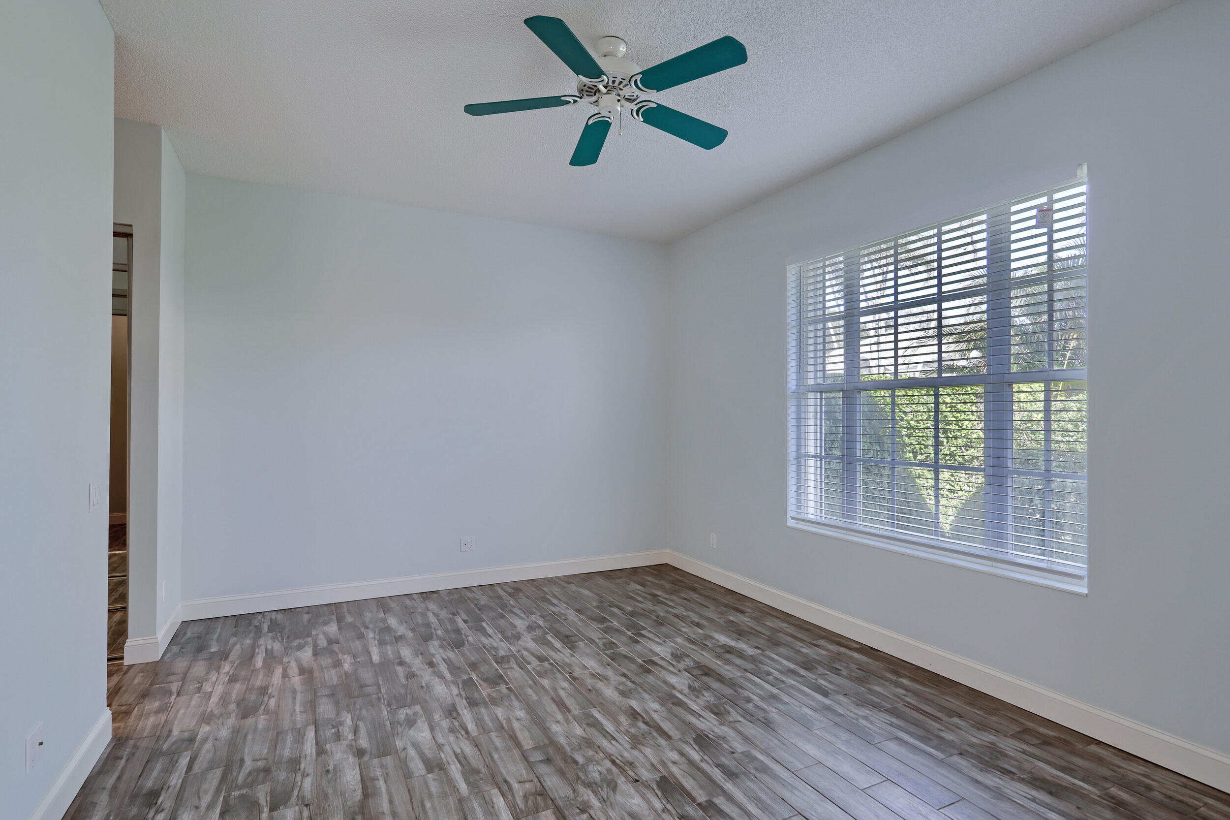 8452 Beaconhill Road Palm Beach Gardens, FL 33410 - Photo 11 of 40 an empty room with a window and a ceiling fan