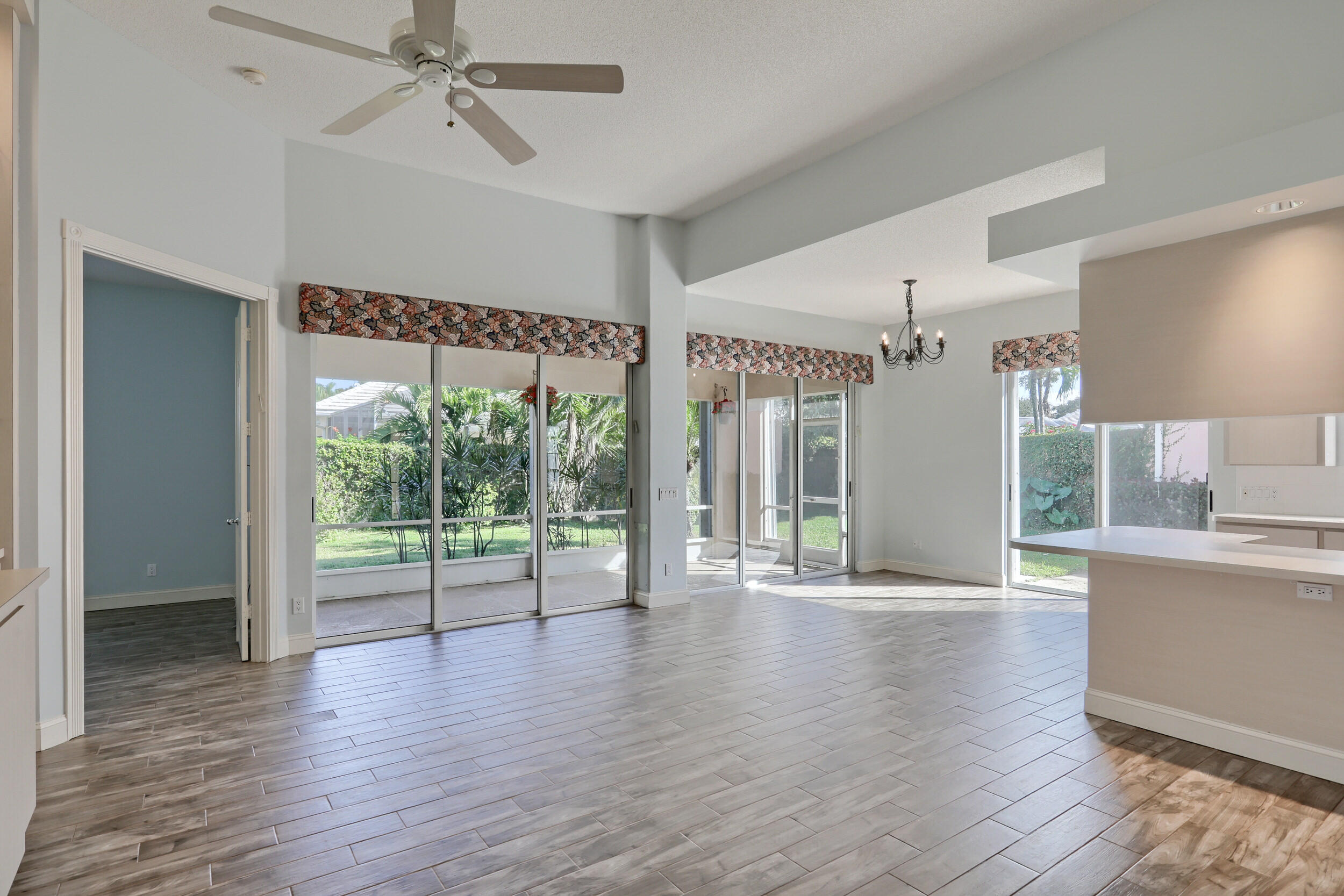 8452 Beaconhill Road Palm Beach Gardens, FL 33410 - Photo 9 of 40 a view of an empty room with wooden floor and a window
