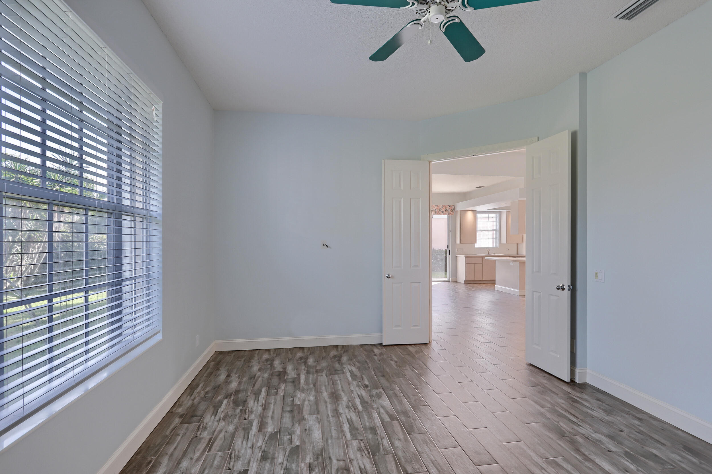 8452 Beaconhill Road Palm Beach Gardens, FL 33410 - Photo 10 of 40 a view of empty room with wooden floor and fan