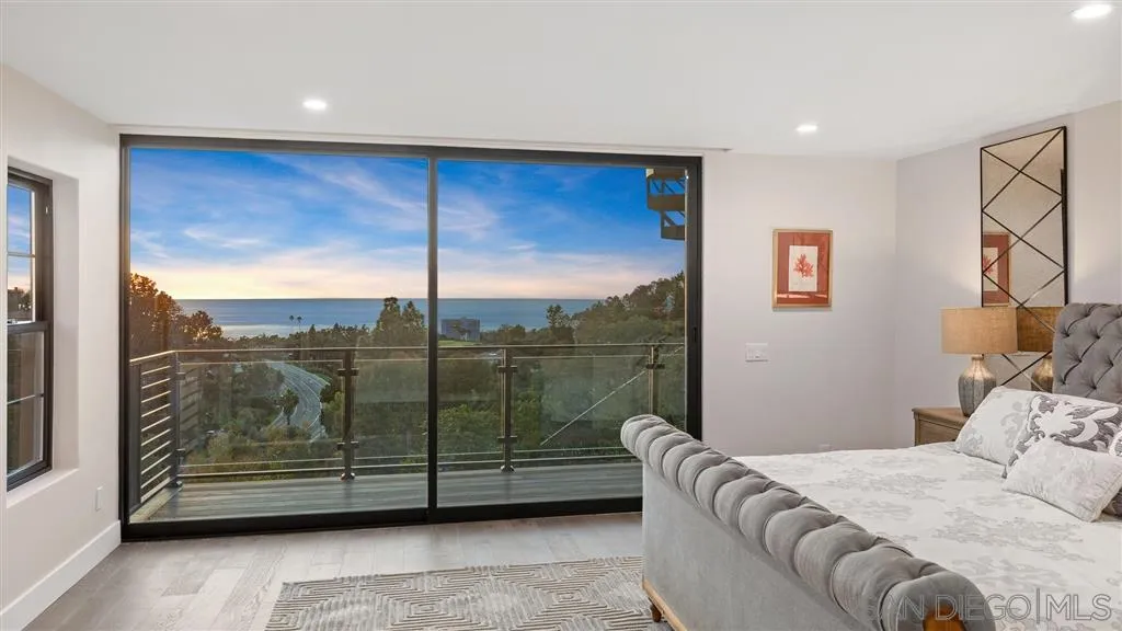 1631 Marisma Way La Jolla, CA 92037 - Photo 16 of 25 a bedroom with a bed and glass window