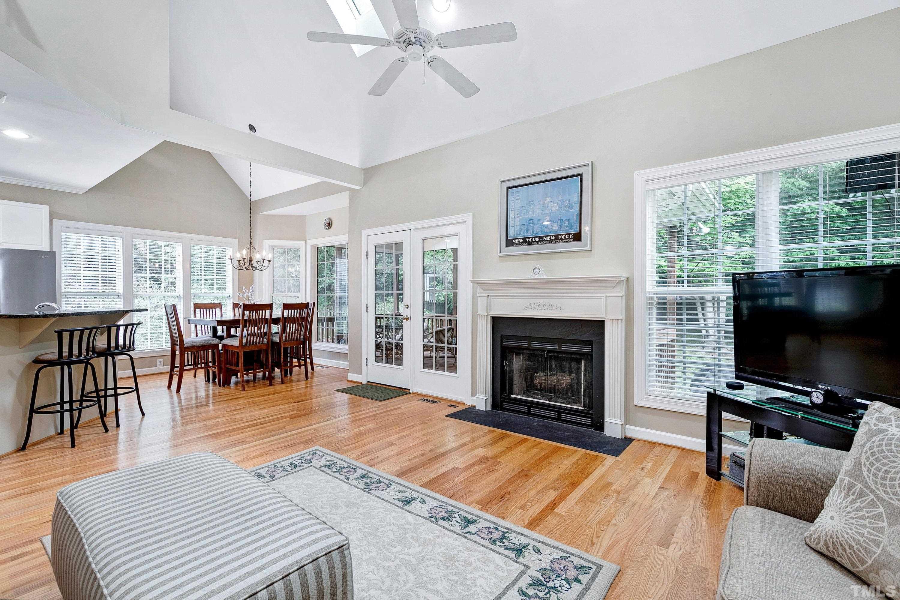 909 Cedar Downs Drive Raleigh, NC 27607 - Photo 12 of 32 a living room with furniture a fireplace and a flat screen tv