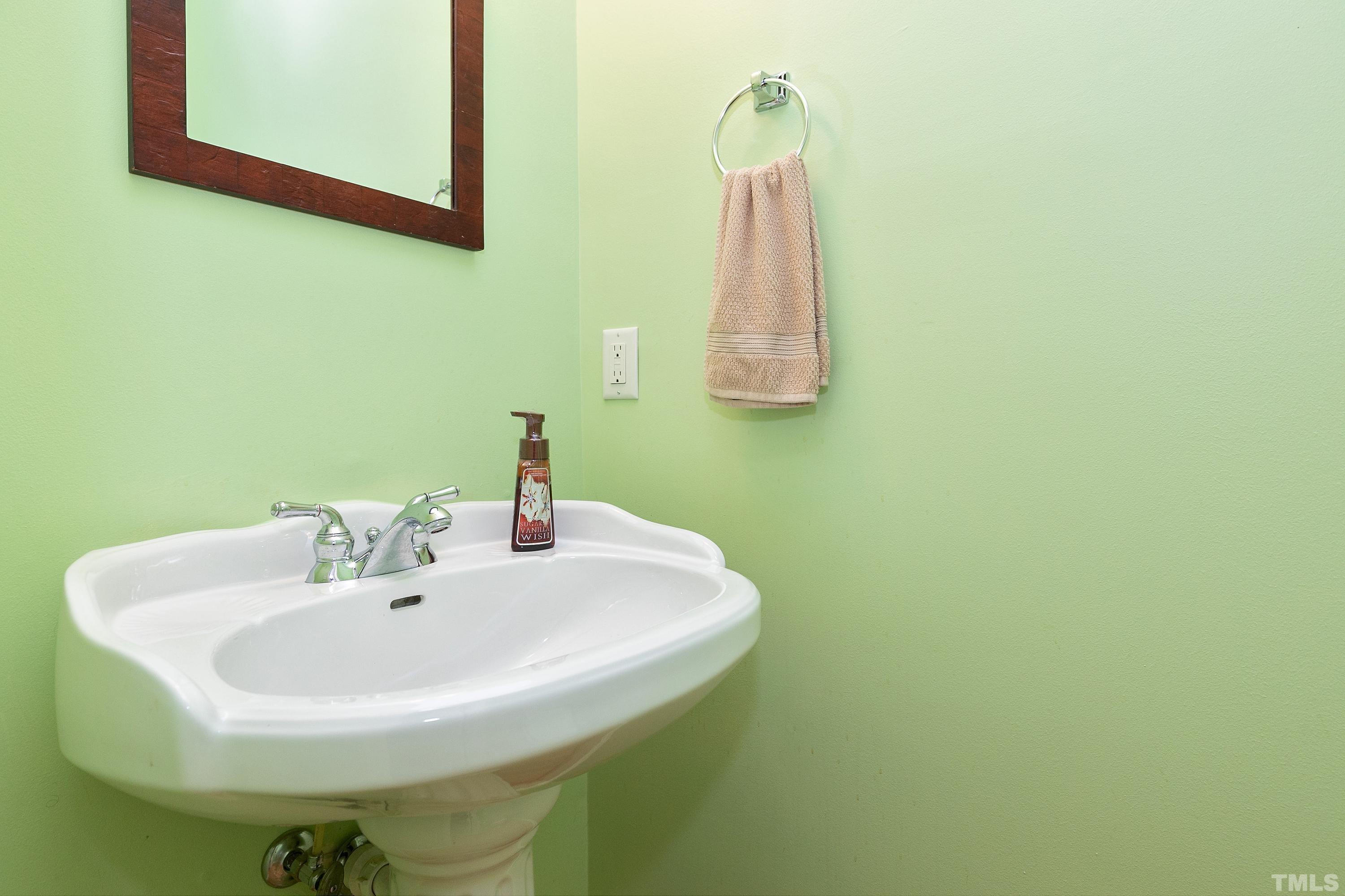 909 Cedar Downs Drive Raleigh, NC 27607 - Photo 14 of 32 a bathroom with a sink and a mirror