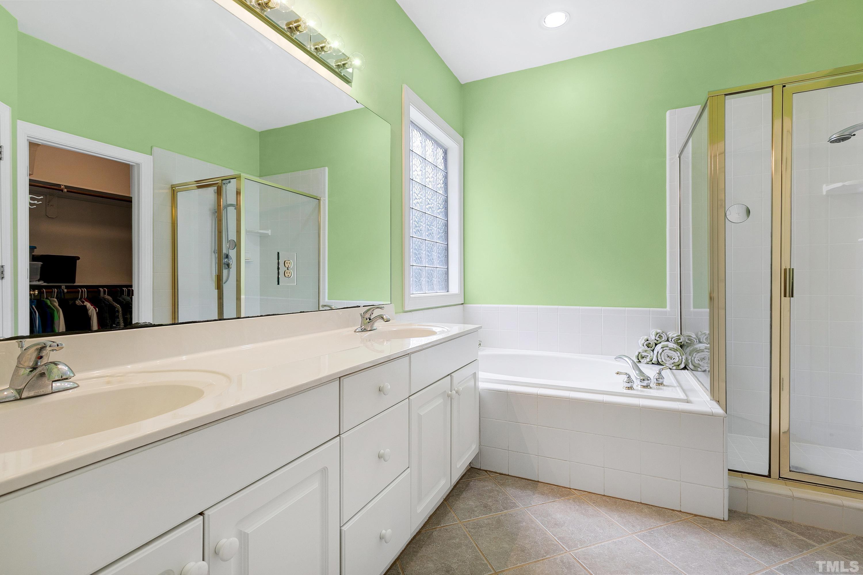 909 Cedar Downs Drive Raleigh, NC 27607 - Photo 20 of 32 a bathroom with a tub sink and mirror