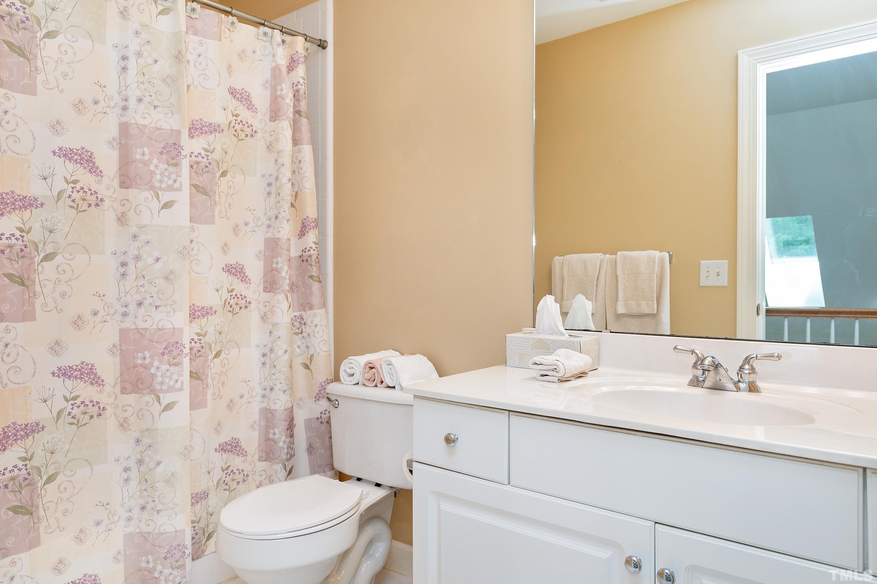 909 Cedar Downs Drive Raleigh, NC 27607 - Photo 23 of 32 a bathroom with a sink a toilet and shower curtain
