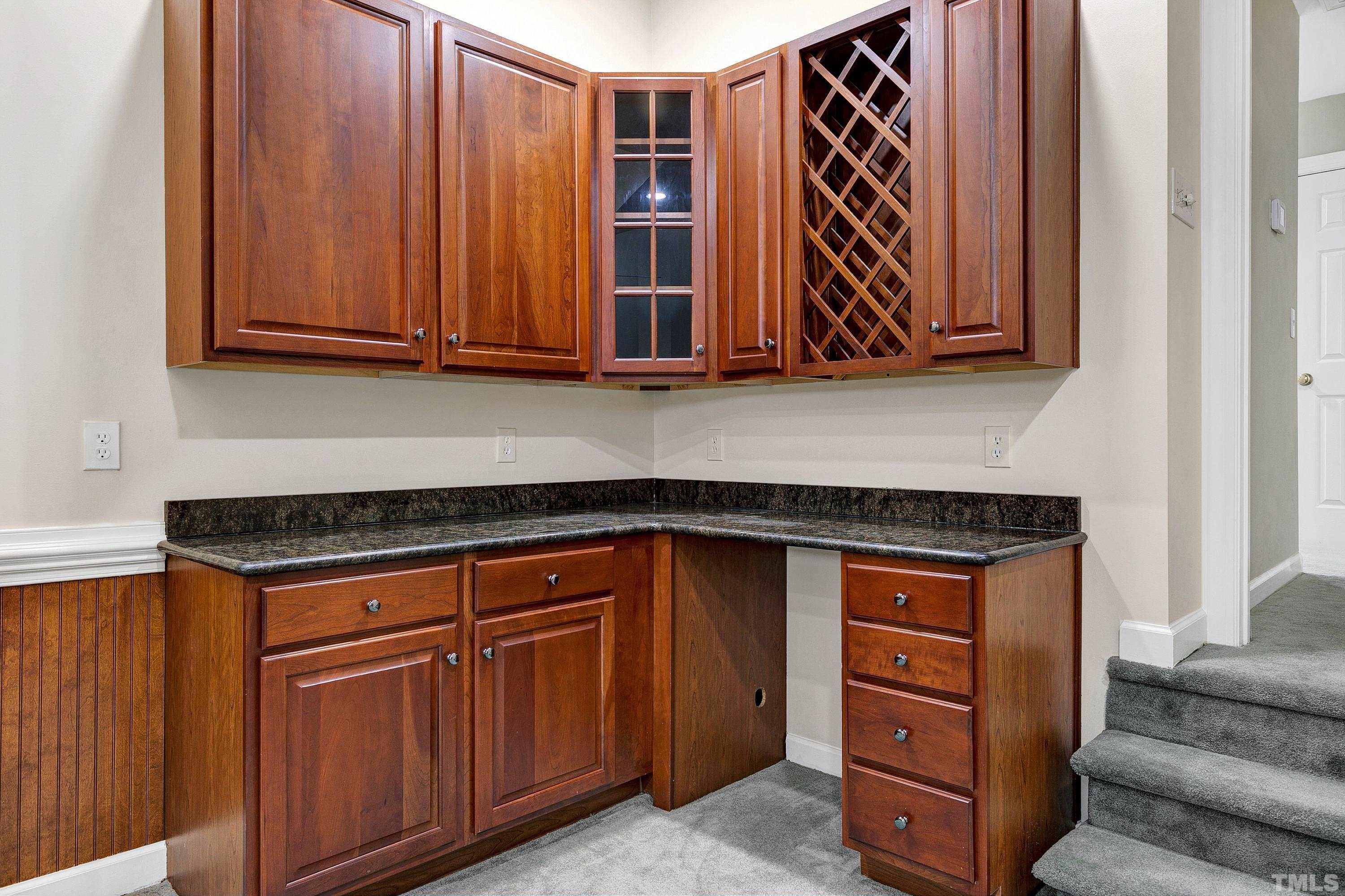 909 Cedar Downs Drive Raleigh, NC 27607 - Photo 28 of 32 a kitchen with wooden cabinets and a stove top oven