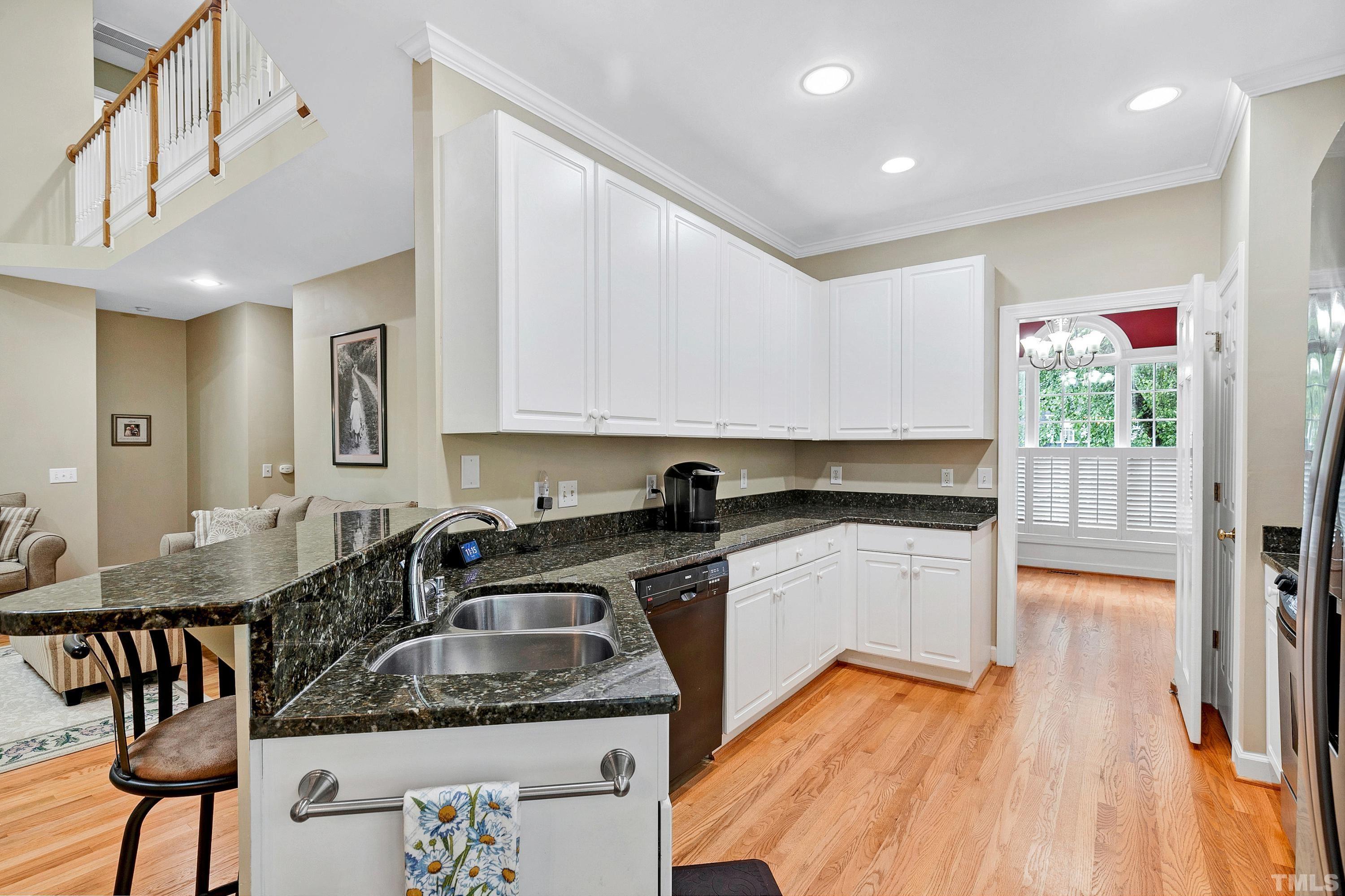 909 Cedar Downs Drive Raleigh, NC 27607 - Photo 8 of 32 a kitchen with stainless steel appliances granite countertop a sink stove and cabinets