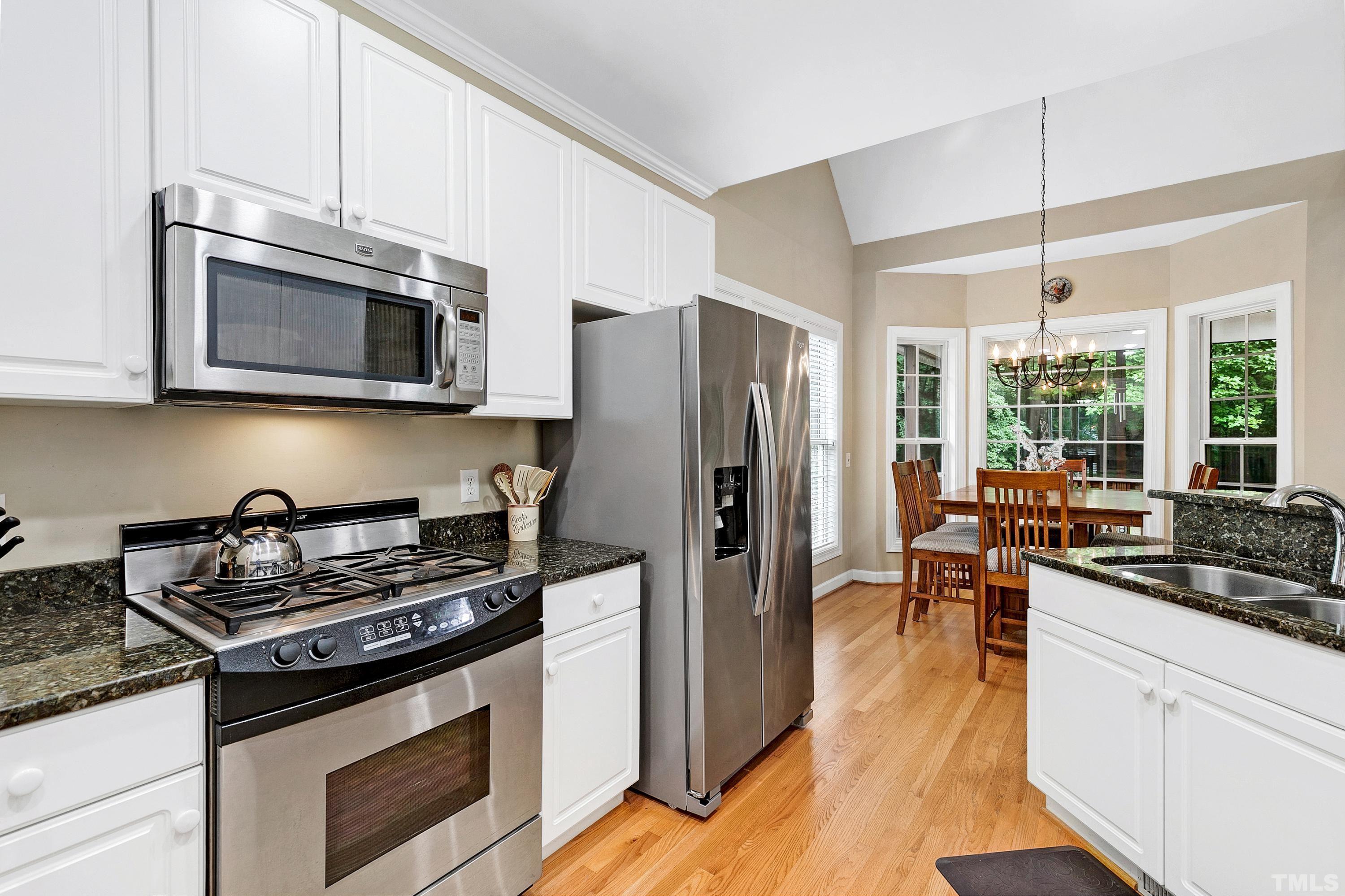909 Cedar Downs Drive Raleigh, NC 27607 - Photo 10 of 32 a kitchen with stainless steel appliances a stove a sink and a refrigerator