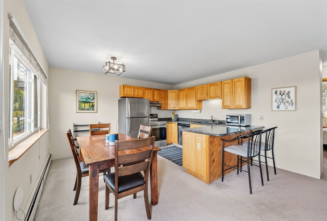 9849 Ryan Gulch Road, Unit 203 Silverthorne, CO 80498 - Photo 13 of 35 a view of a dining room with furniture and a kitchen