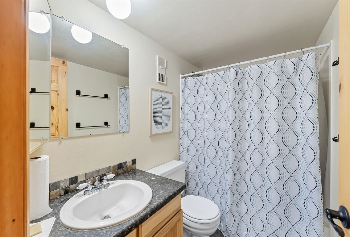 9849 Ryan Gulch Road, Unit 203 Silverthorne, CO 80498 - Photo 20 of 35 a bathroom with a sink a toilet and a mirror